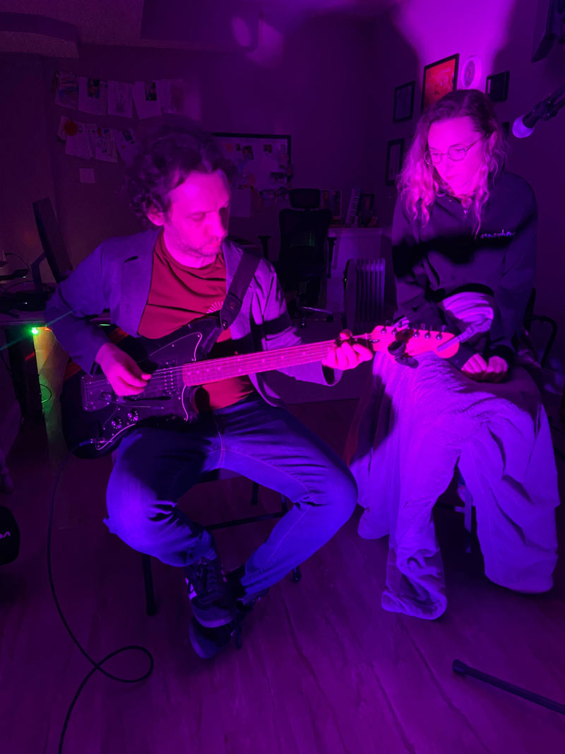 A photo of Damien playing the guitar