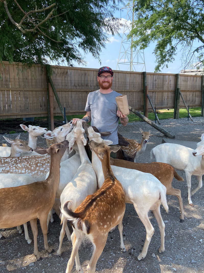 A photo of Jake feeding a group of deer