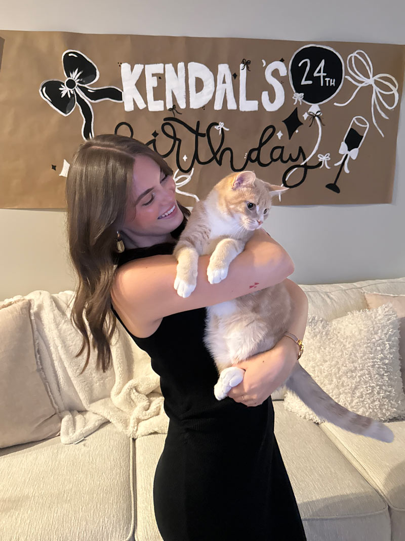A photo of Kendal holding her cat at her birthday party