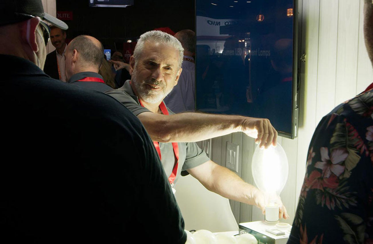 A man presents an LED lamp at Lightfair
