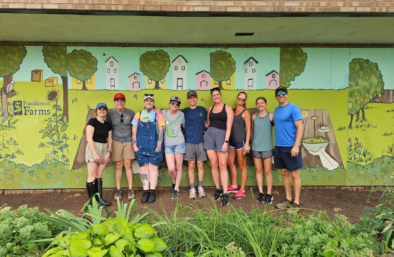 Giving Back To Our Community YLB Team members stand in front of a mural at Franklinton Farms after a day of volunteering